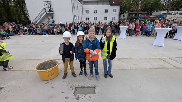 4 Kinder mit Bauarbeiter-Ausstattung, die gerade die Zeitkapsel einzementiert haben